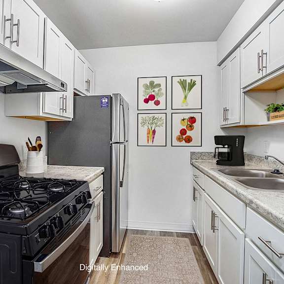 Thumbnail 7 of 13 An upgraded kitchen with white cabinets and stainless steel appliances at Wingate Apartments, Michigan