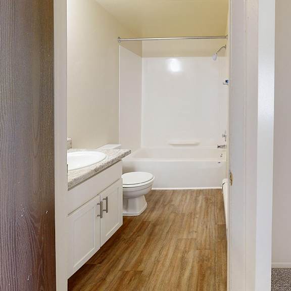 Thumbnail 7 of 8 A bathroom with a toilet, sink, and bathtub at Wood Creek Apartments, Kenosha, WI, 53144