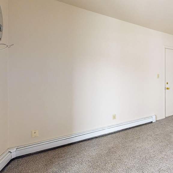 Thumbnail 5 of 8 A living and dining room with a carpeted floor at Wood Creek Apartments, Kenosha, WI, 53144