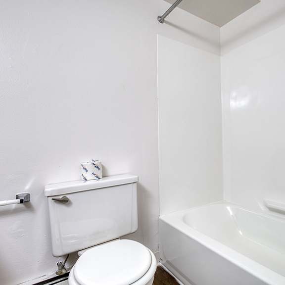 Thumbnail 8 of 14 A bathroom with a bathtub and toilet at Wood Creek Apartments, Kenosha