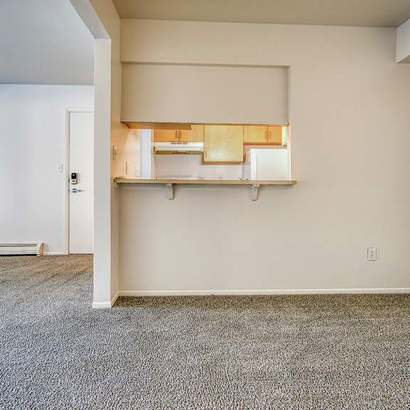 Thumbnail 4 of 14 A dining room with a carpeted floor and a breakfast bar at Wood Creek Apartments, Kenosha