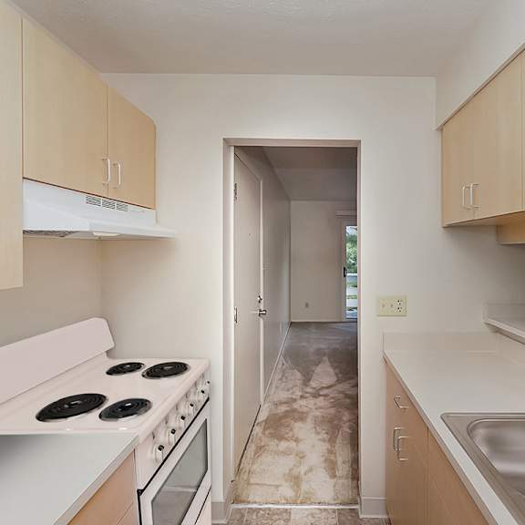 Thumbnail 5 of 8 A kitchen with a white electric stove top oven at Wood Creek Apartments in Kenosha, WI
