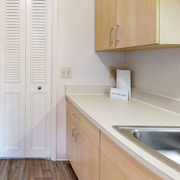 Thumbnail 4 of 8 A kitchen with a white fridge and wooden cabinets at Wood Creek Apartments in Kenosha, WI