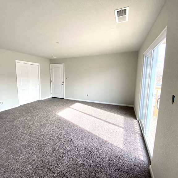 a large empty room with carpeted floor and white walls.