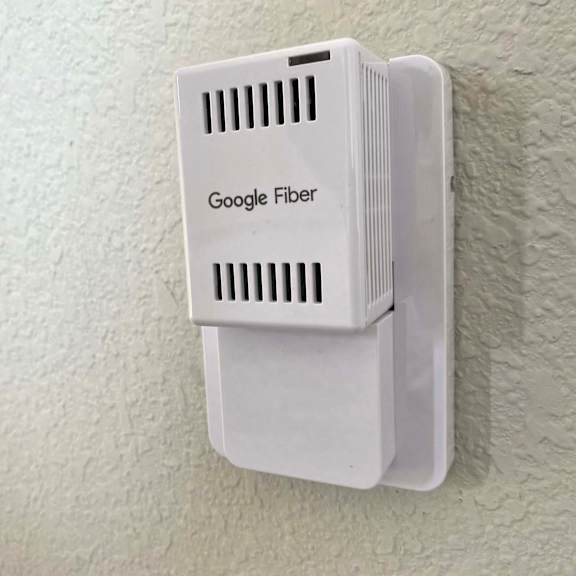 a google fiber box mounted on a wall.