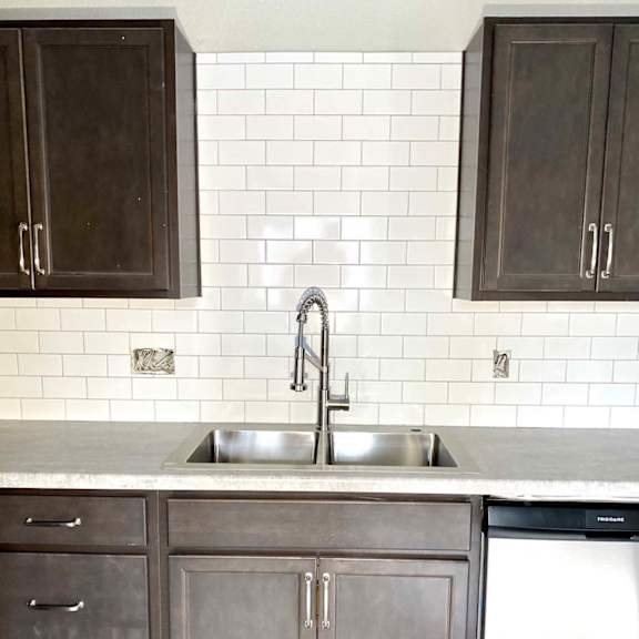 a kitchen with a white sink and a white dishwasher.