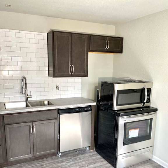 a kitchen with a black microwave oven on a black cabinet.