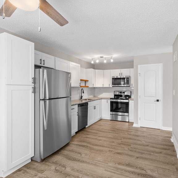 a kitchen with a refrigerator, oven, and sink.