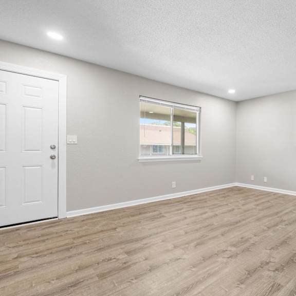 a room with a white door and a window with a view of a building.