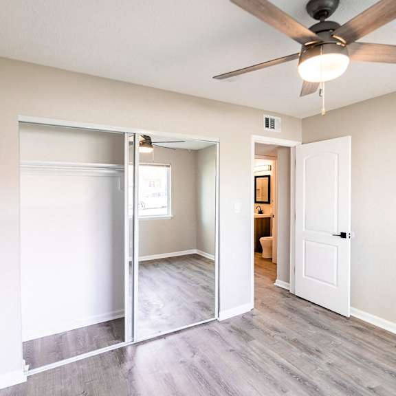a room with a ceiling fan and a sliding door.