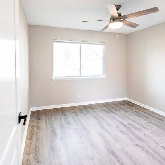a room with a ceiling fan and a window.