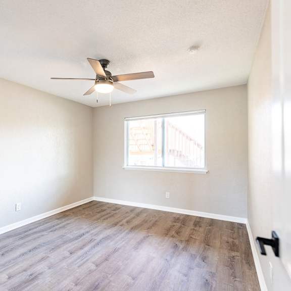 a room with a ceiling fan and a window.