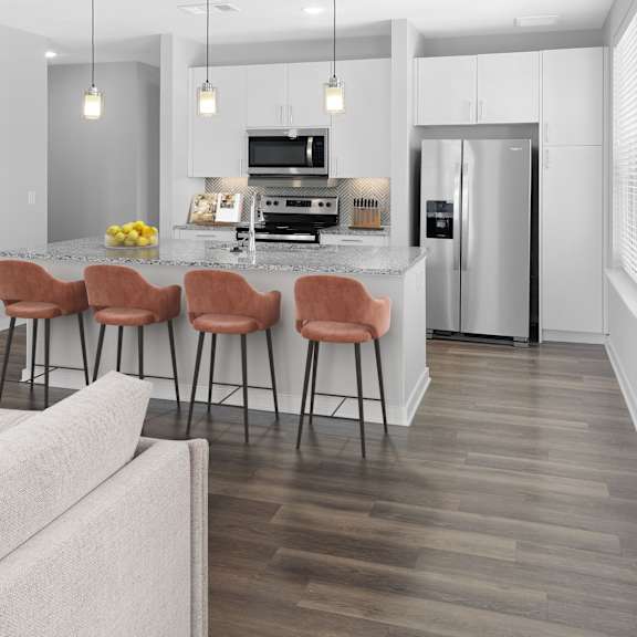 Thumbnail 6 of 6 A modern kitchen with a bar area and a refrigerator.