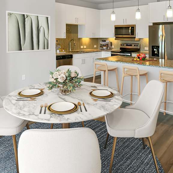 Thumbnail 4 of 5 A modern dining room with a marble table and white chairs.