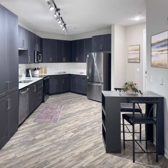 Thumbnail 2 of 5 A kitchen with dark wood cabinets and a black island.