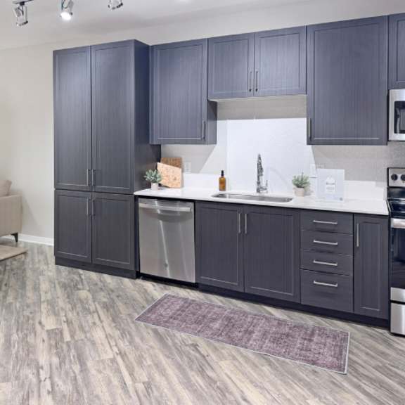 Thumbnail 3 of 5 A kitchen with dark wood cabinets and a white backsplash.