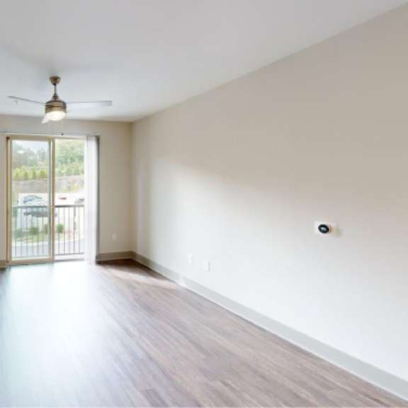 Thumbnail 11 of 11 A room with a sliding glass door leading outside.