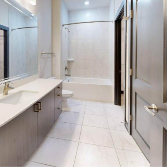 Thumbnail 2 of 10 A bathroom with a sink, mirror, and toilet.