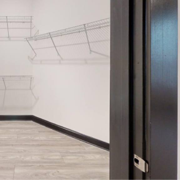 Thumbnail 5 of 10 A white wall with a black door and a black frame.