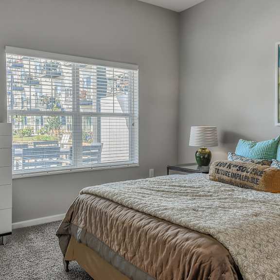 a bedroom with a bed and a large window