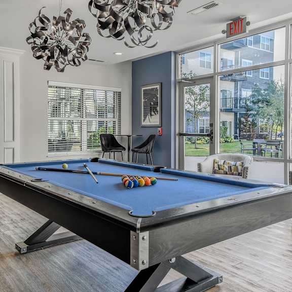 a pool table in a living room with a large window