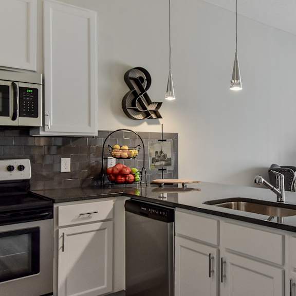 an open kitchen and living room with a large counter top