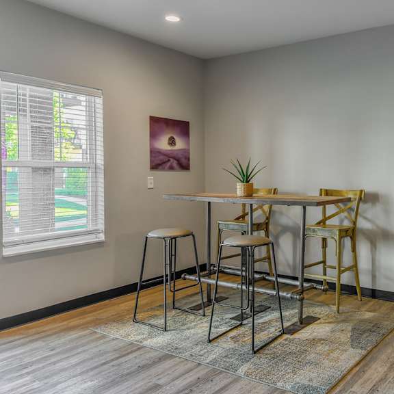 a dining area with a table and chairs and a window