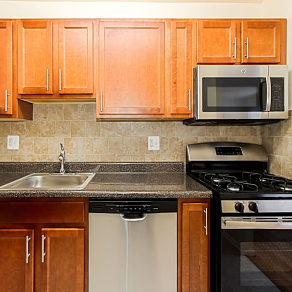 a kitchen with wooden cabinets and a sink and a stove