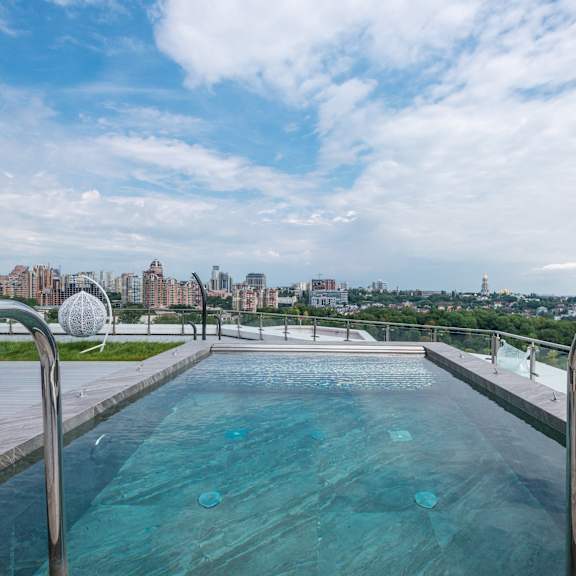 a swimming pool on the roof of a building with a city in the background