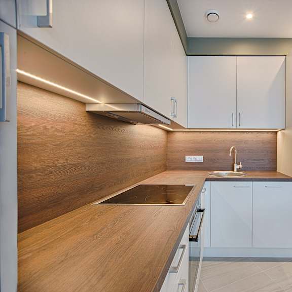 a kitchen with white cabinets and a wooden counter top