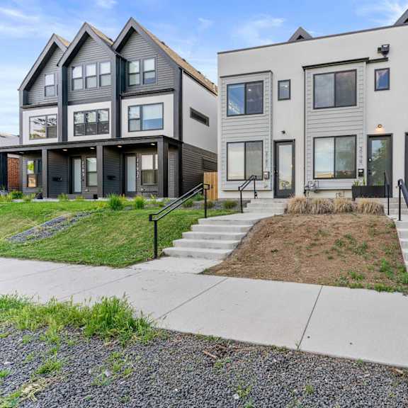 a group of houses in a row with a sidewalk in front of them