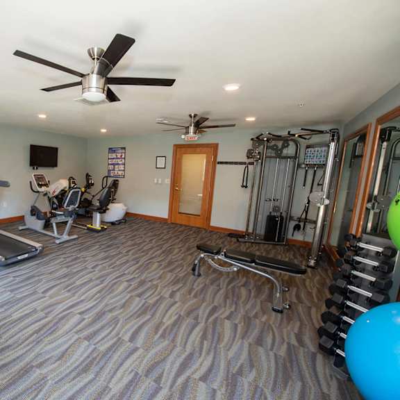 a spacious gym with treadmills, elliptical machines, and other exercise equipment.