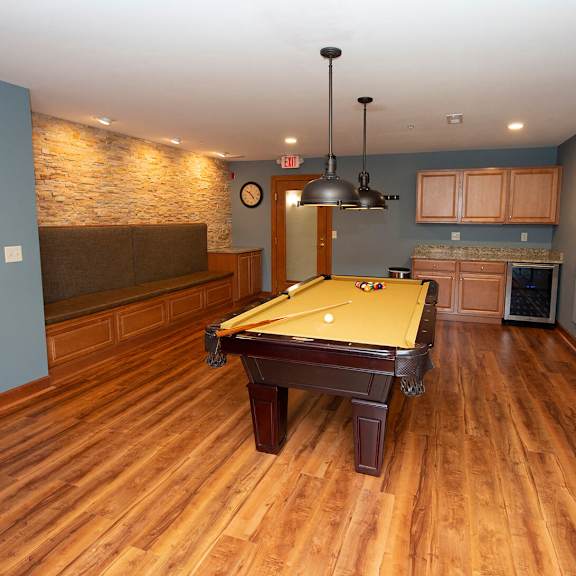 a pool table in the middle of a room with wooden floors.