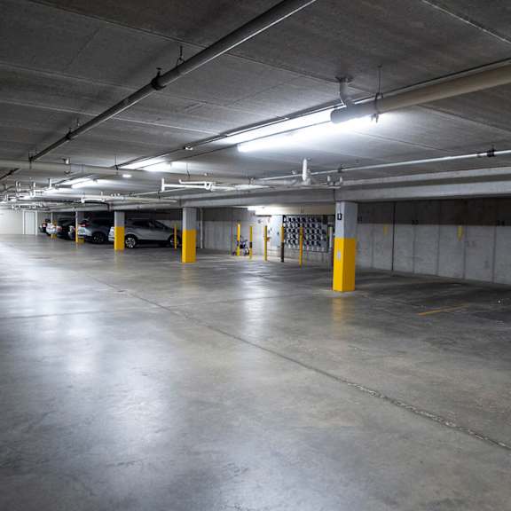 a spacious, empty parking garage with concrete floors and yellow poles.