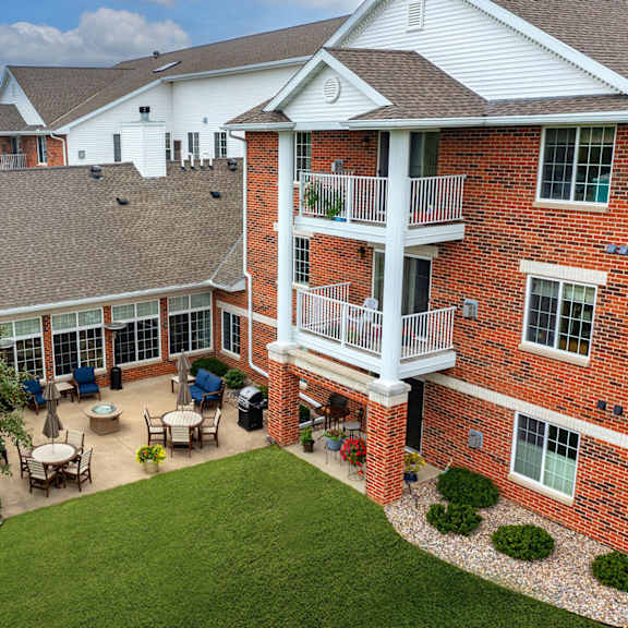 an aerial view of a large brick building with a balcony and a patio with a table and