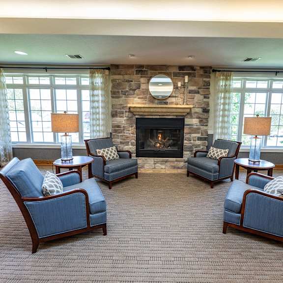 a living room with a fireplace and four chairs.