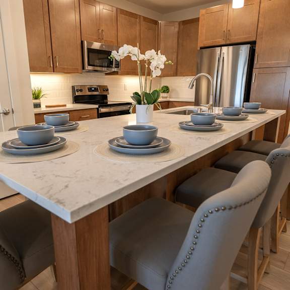 a kitchen with a marble table with plates and bowls on it