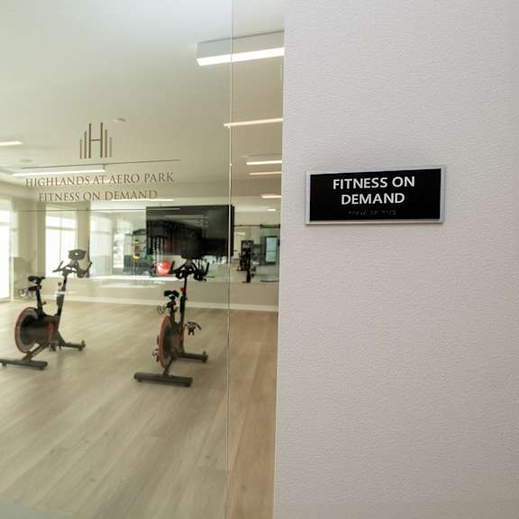 a gym with a sign that reads fitness on demand on a glass wall