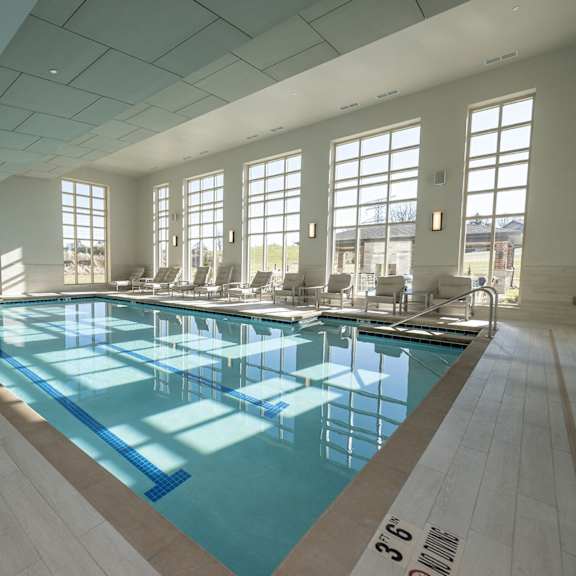 a view of an indoor pool with windows looking to the outside.