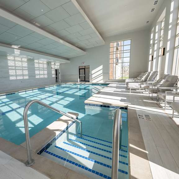 a large indoor swimming pool with lounge chairs.