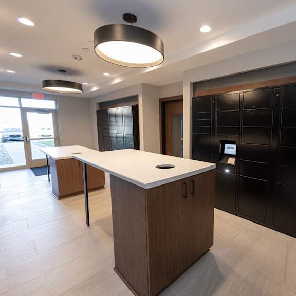 a center countertop in the middle of a mailroom with black cabinets.