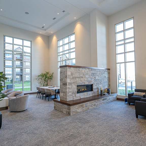 a large lobby area with a stone fireplace and large windows.