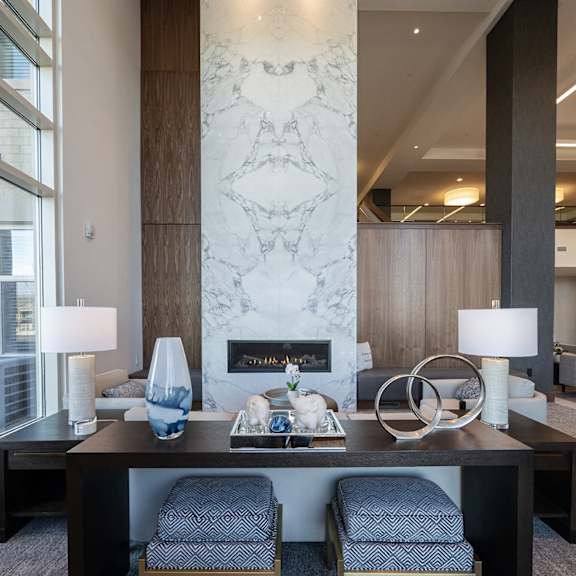 a lobby area with a fireplace and two chairs.