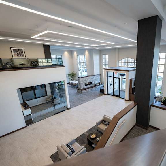 a large open view of the lobby space with a fireplace and a view of the outside.