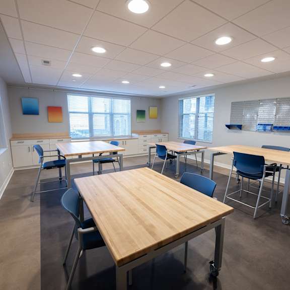 a room with tables, chairs, and a window.