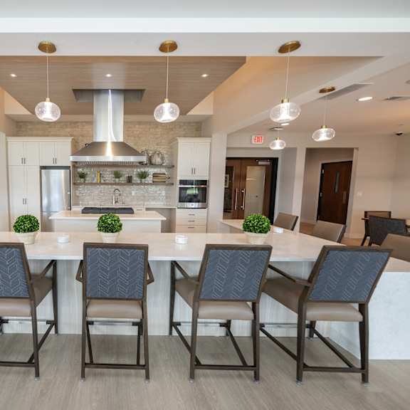 a large kitchen with a large island and chairs in front of a dining table