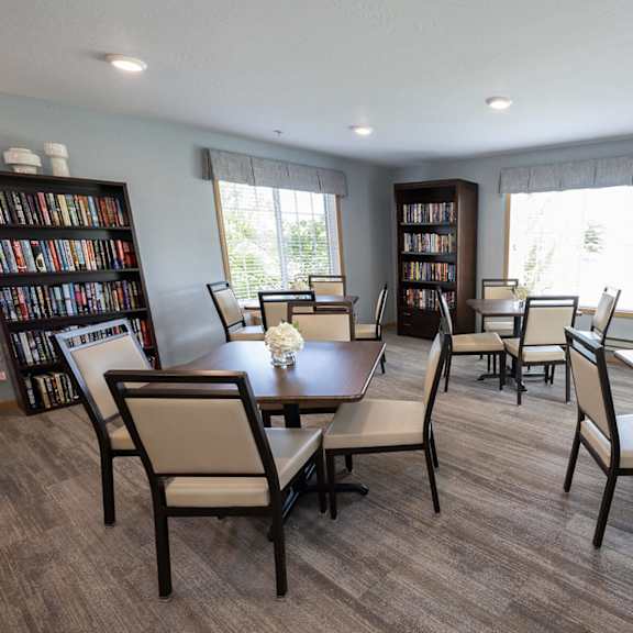 a dining room with a table and chairs and two bookcases with books