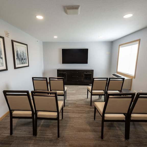 a small conference room with chairs and a tv on the wall