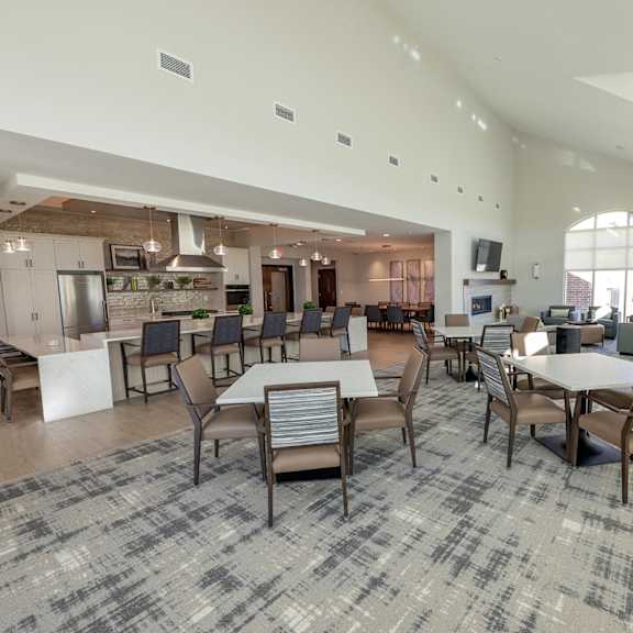 a large dining room with tables and chairs and a kitchen
