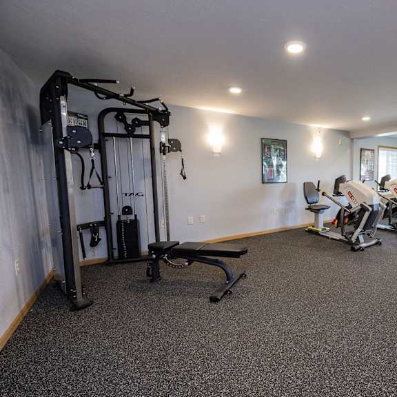 a gym with exercise equipment and a tv
